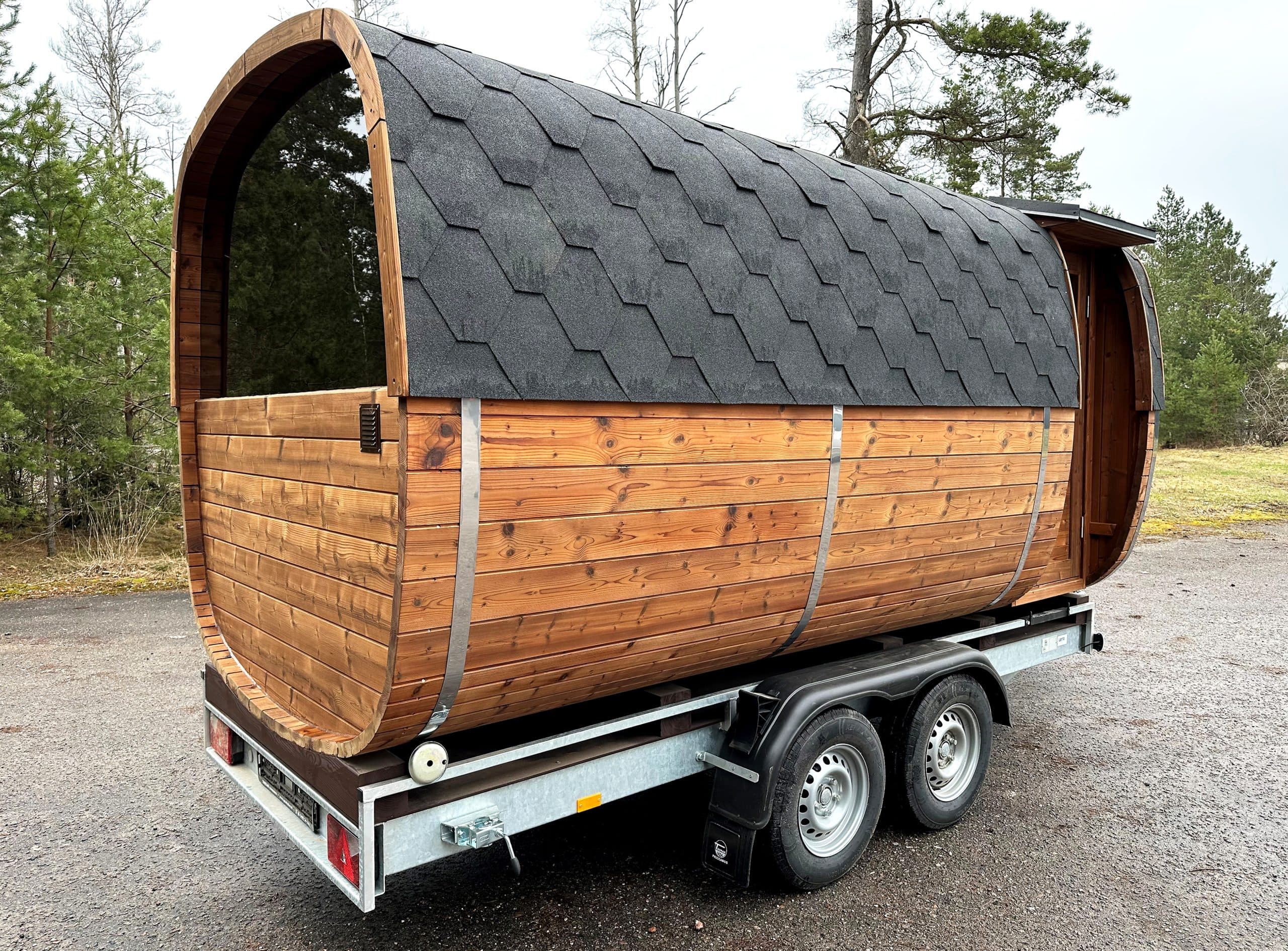 Cedar barrel mobile sauna trailer parked in a garden setting